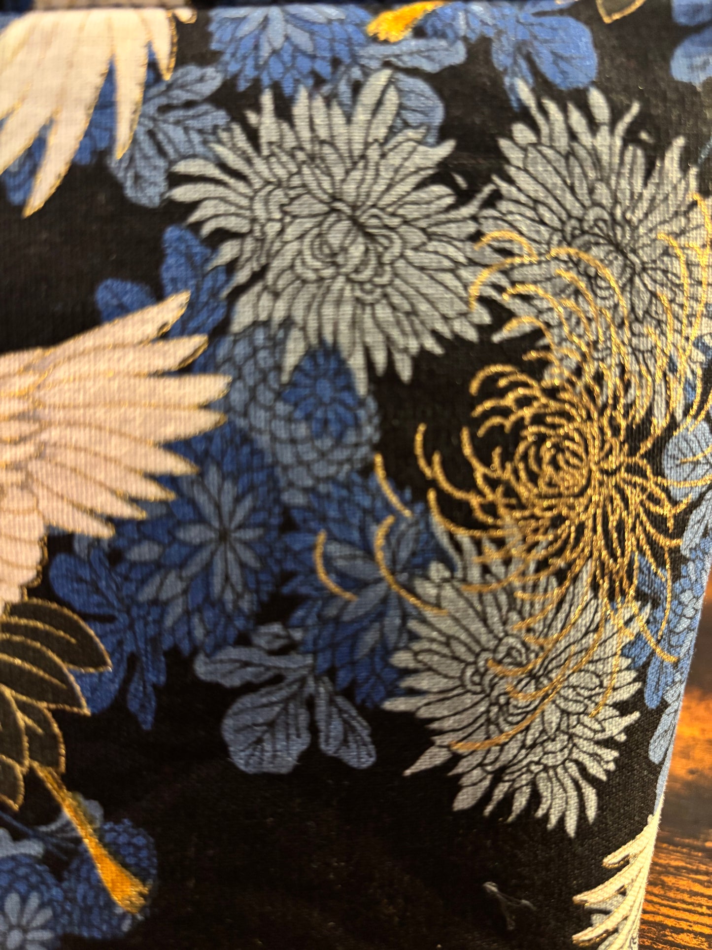 Crane print blue small makeup storage bag with gold foil detail. Gold tassel and red cotton lining.
