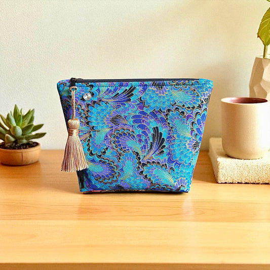 Blue pheonix print small makeup storage bag with gold foil detail. Gold tassel and red cotton lining.