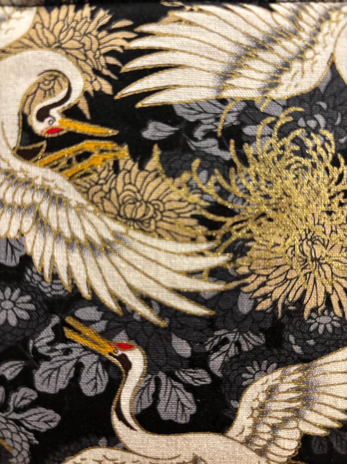 Crane print black small makeup storage bag with gold foil detail. Gold tassel and red cotton lining.