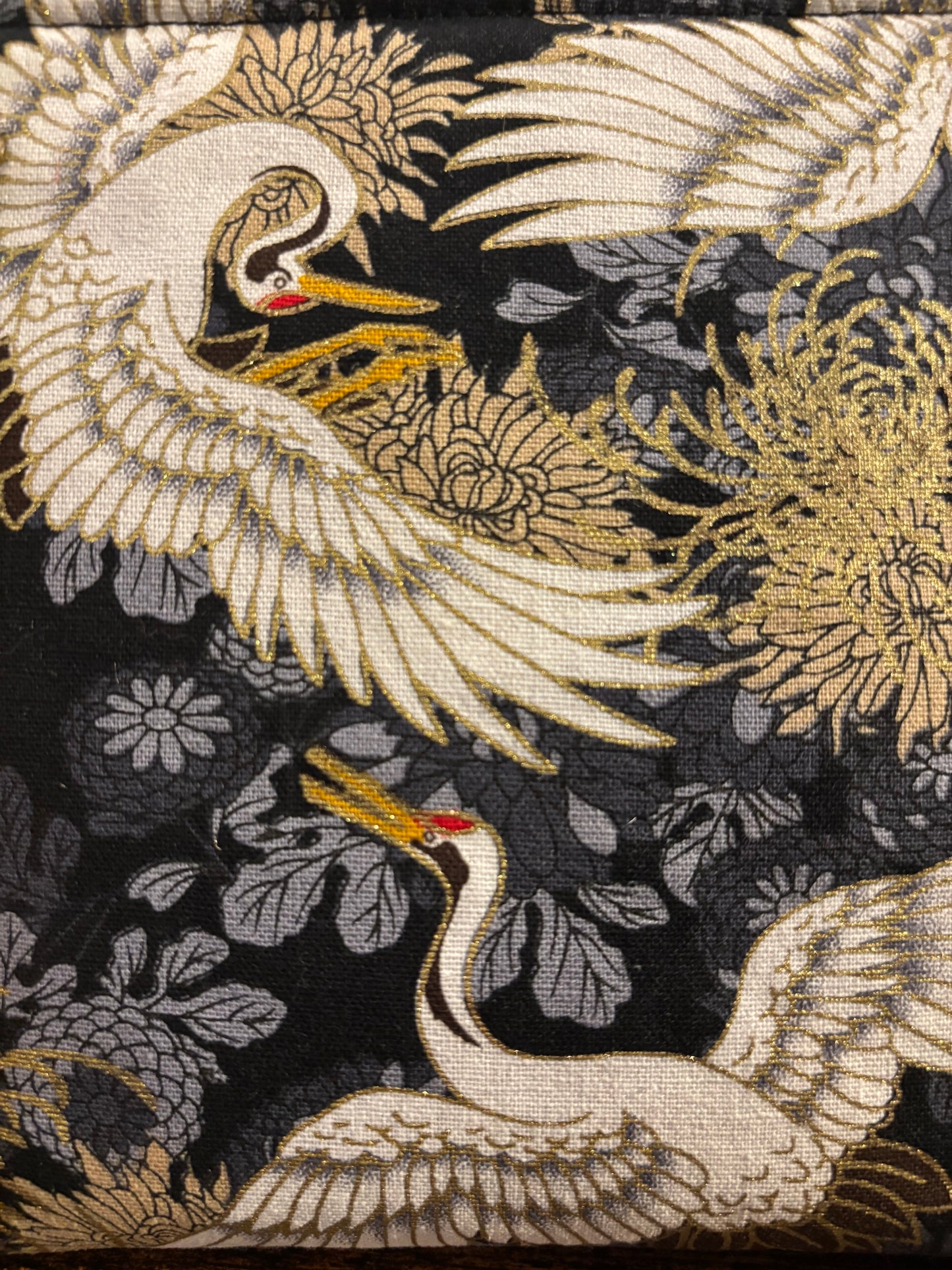 Crane print black small makeup storage bag with gold foil detail. Gold tassel and red cotton lining.