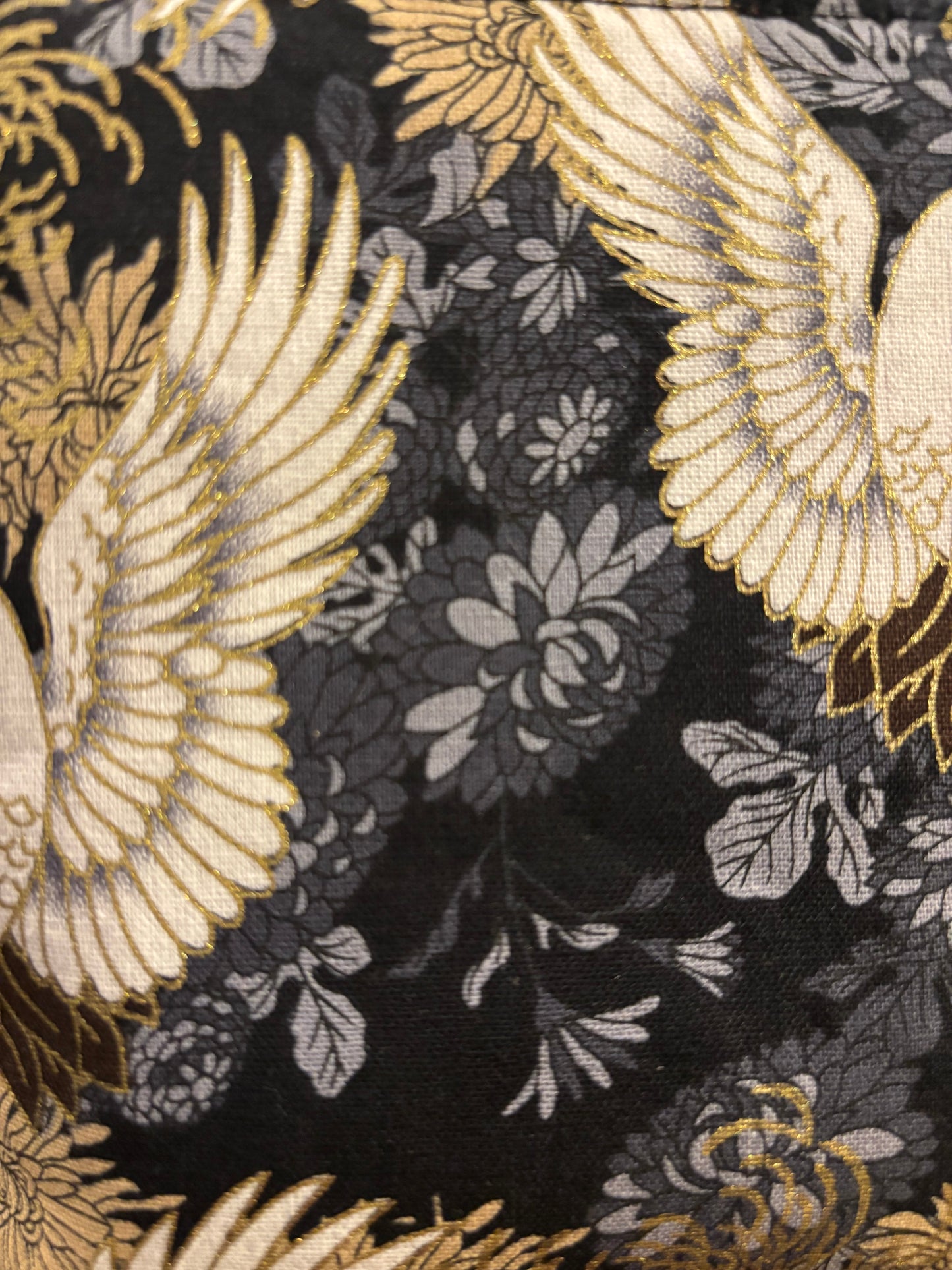 Crane print black small makeup storage bag with gold foil detail. Gold tassel and red cotton lining.