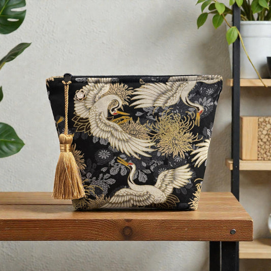 Crane print black small makeup storage bag with gold foil detail. Gold tassel and red cotton lining.