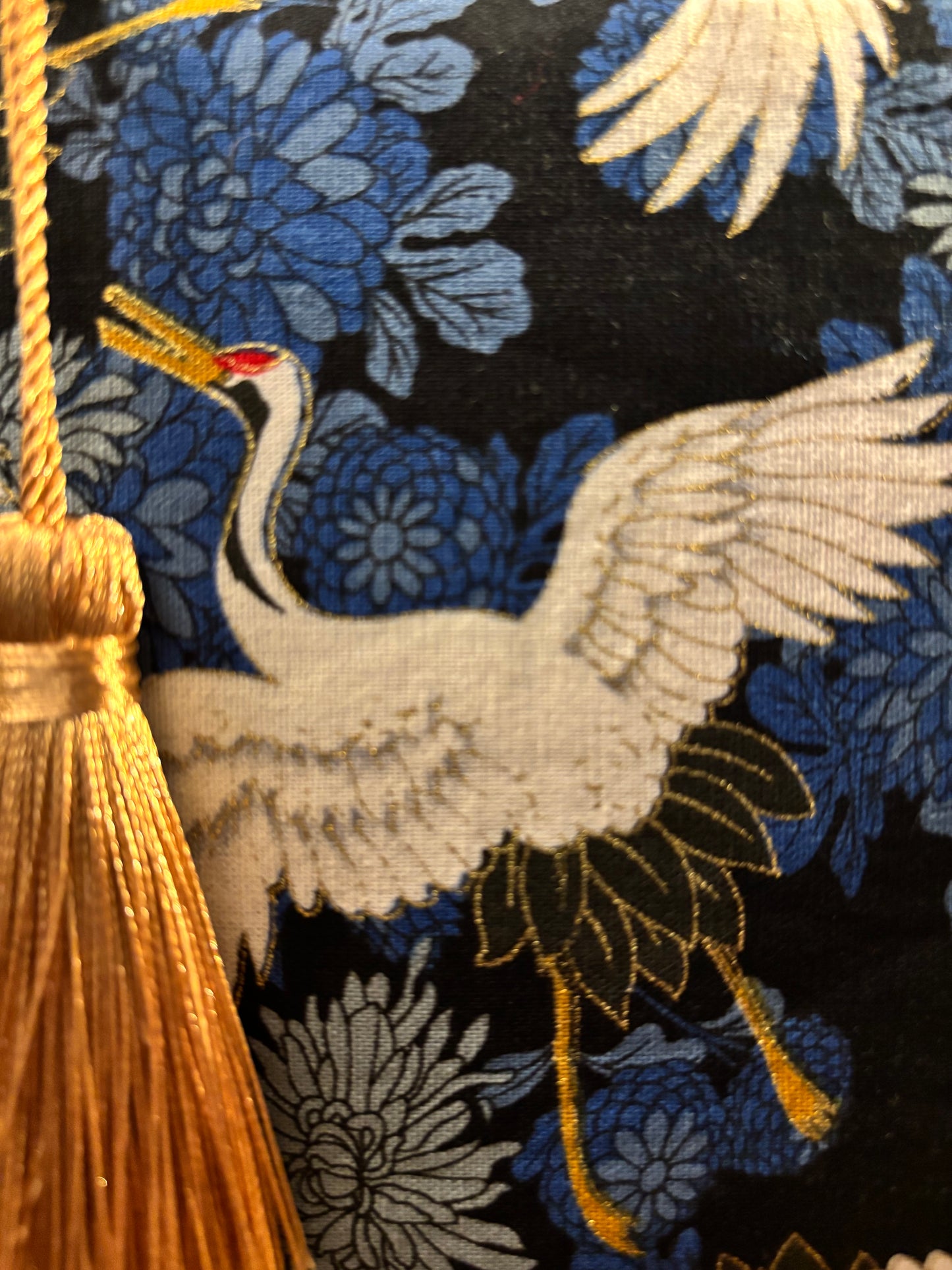 Crane print blue small makeup storage bag with gold foil detail. Gold tassel and red cotton lining.